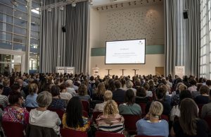 Auf dem Bild zu sehen sind viele Menschen, meist Lehrkräfte, die einem Vortrag auf den Fachtagen 2023 der BiSS-Akademie NRW folgen.