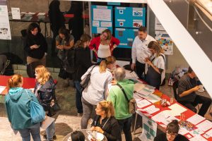 Das Bild zeigt Personen, die sich auf dem Fachtag der BiSS-Akademie NRW 2024 an einem Informationsstand informieren.